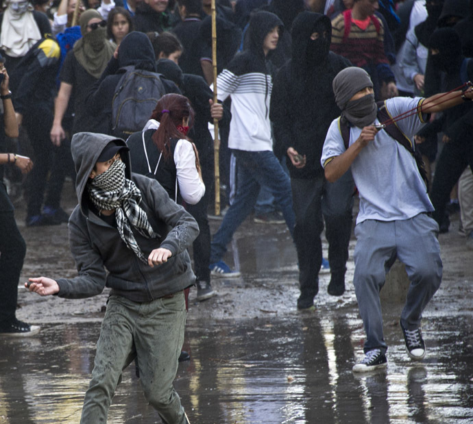 Students clash with riot police during a protest against the education system, in Santiago, on May 8, 2014. (AFP Photo)