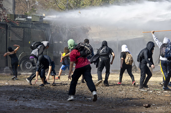 Students clash with riot police during a protest against the education system, in Santiago, on May 8, 2014.(AFP Photo)