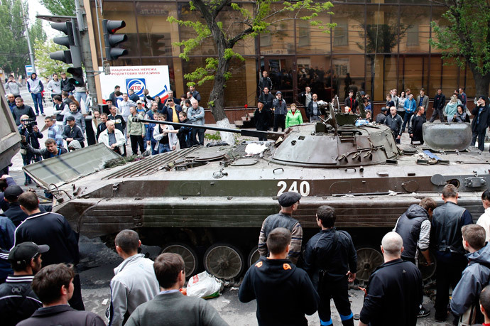 A broken armoured vehicle left behind by Ukrainian forces is taken away by pro-Russian militants in Mariupol May 9, 2014.(Reuters / Marko Djurica)