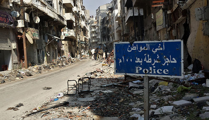 A road sign is seen as Syrian government forces walk in a street on May 9, 2014 in the Christian neighborhood of Hamidiyeh in the old city of Homs after Syrian government forces regained control of rebel-controlled areas. (AFP Photo / Youssef Karwashan)