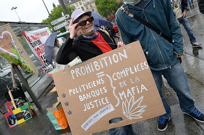 A woman holds a placard reading "Prohibition equals politicians, banks, justice, all accomplices of the Mafia" as she takes part in a protest to call for the legalization of marijuana on May 10, 2014 in Paris. (AFP Photo / Pierre Andrieu)