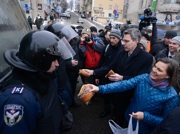 U.S. Assistant Secretary of State for European and Eurasian Affairs Victoria Nuland (R) and U.S. Ambassador Geoffrey Pyatt (2nd R) distribute bread to riot police near Independence square in Kiev December 11, 2013 (Reuters)