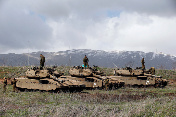 Israeli soldiers stand atop tanks in the Golan Heights near Israel's border with Syria March 19, 2014 (Reuters / Ronen Zvulun)