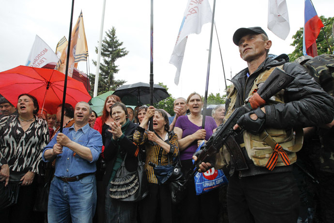 An anti-Kiev armed man stands guard as people hold a rally to mark and celebrate the announcement of the results of the referendum on the status of Luhansk region in Luhansk May 12, 2014. (Reuters/Valentyn Ogirenko)