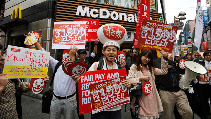 Demonstrators holding posters march during a protest to demand higher wages for fast-food workers in front of a McDonald's fast-food restaurant in Tokyo's Shibuya shopping and amusement district May 15, 2014.(Reuters / Toru Hanai )