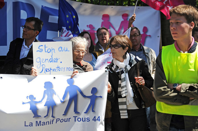 An anti-gay marriage protester of 'La Manif pour tous' movement holds a sign reading 'stop the gender, let's respect ourselves' as she protests with other people against the so called 'Ce que souleve la jupe' ('What raises the skirt') event in high schools on May 15, 2014, in front of the Clemenceau high school in Nantes, western France.(AFP Photo / Jean-Sebastien Evrard )
