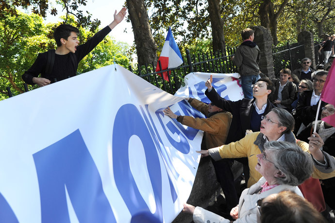 Anti-gay marriage protesters of 'La Manif pour tous' (R) clash with a student (L) as they protest against the so called 'Ce que souleve la jupe' ( "What raises the skirt?") event in high schools on May 15, 2014, in front of the Clemenceau high school in Nantes, western France. (AFP Photo / Jean-Sebastien Evrard )