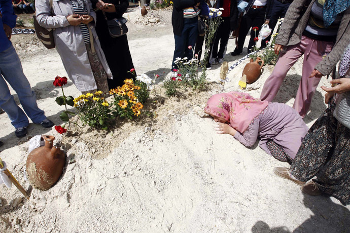 Relatives of a miner mourn beside his grave after a mining disaster in Soma, a district in Turkey's western province of Manisa May 16, 2014. (Reuters/Osman Orsal)
