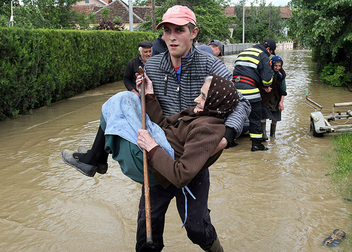 A Serbian rescuer carries an elderly woman out of her flooded house in the village of Obrez, near the central Serbian town of Varvarin, south of Belgrade, on May 17, 2014. (AFP Photo / Sasa Djordjevic)