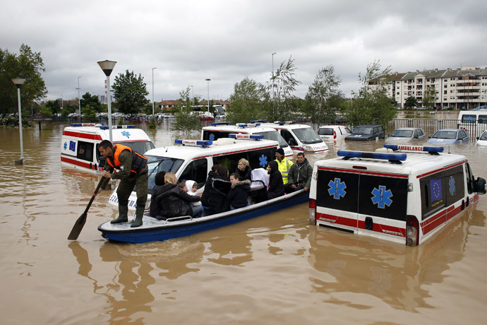 A Serbian rows a boat past flooded ambulance vehicles in the flooded town of Obrenovac, southwest of Belgrade, Serbia May 17, 2014. (Reuters/Marko Djurica)
