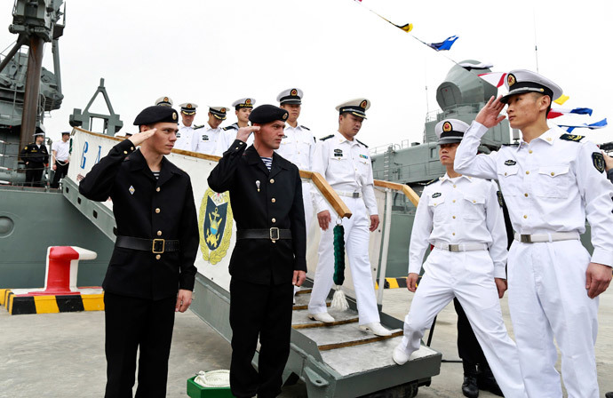 Russian sailors (L) salute to Chinese sailors as they visit Russian guided missile cruiser Varyag ahead of the "Joint Sea-2014" naval drill, at a port in Shanghai, May 19, 2014.(Reuters / China Daily)