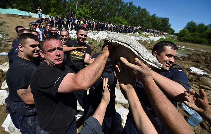 Volunteers and police officers pass sandbags to reinforce the bank of the river Sava near Sabac, 100 kilometres west of Belgrade, on May 19, 2014. (AFP Photo / Andrej Isakovic)