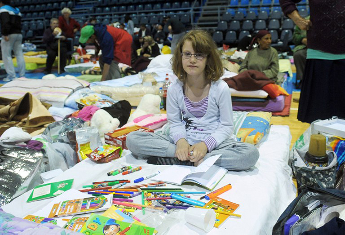 A girl sits on a matress with coloured felt pens and books in a collective centre for people evacuated from the flooded town of Obrenovac on May 19, 2014 in Obrenovac, some 30km southwest of Belgrade. (AFP Photo / Alexa Stankovic)