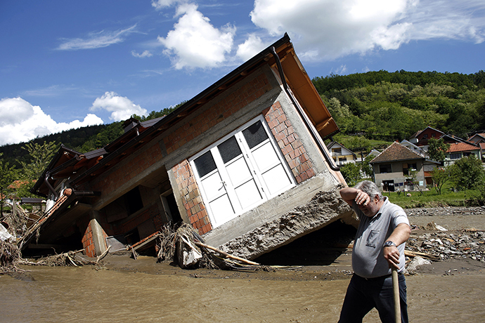 A man reacts near a house tilted by floods in the village of Krupanj, west from Belgrade, May 19, 2014. (Reuters / Marko Djurica)