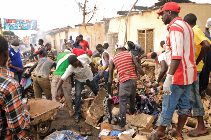Stallkeepers salvage their belongings as rescuers and residents gather at the charred scene following a bomb blast at Terminus market in the central city of Jos on May 20, 2014 (AFP Photo / STR)