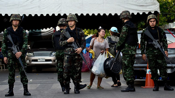 A Thai anti-government protester (C) leaves the main camp-site near the Government House in Bangkok on May 23, 2014 a day after Thai military seized power. (AFP Photo / Manan Vatsyayana)