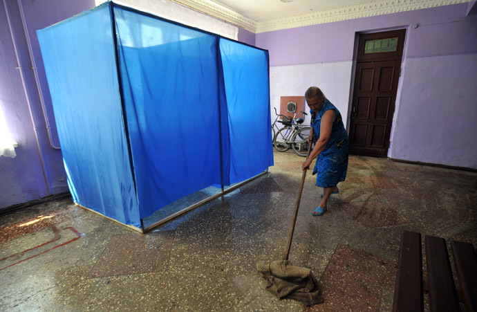 A members of the election comission mops the floor of a pooling station ahead of the upcoming Ukrainian presidential election at the Octyabr village in the Donetsk region on May 22, 2014. (AFP Photo/Genya Savilov)