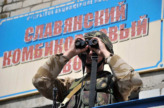 A Ukrainian army soldier looks through binoculars as he stands guard at a checkpoint outside of Slavyansk, on May 25, 2014. (AFP Photo / Genya Savilov)