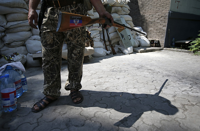 An armed supporter of the self-proclaimed Donetsk People's Republic stands guard at a newly erected barricade on a road which leads to an airport in the eastern Ukrainian city of Donetsk May 28, 2014. (Reuters / Maxim Zmeyev)