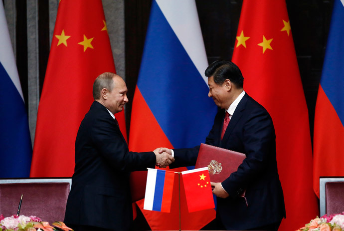 Russia's President Vladimir Putin (L) and China's President Xi Jinping shake hands after signing an agreement during a bilateral meeting at the Xijiao State Guesthouse ahead of the fourth Conference on Interaction and Confidence Building Measures in Asia (CICA) summit, in Shanghai on May 20, 2014.( AFP Photo / Carlos Barria)