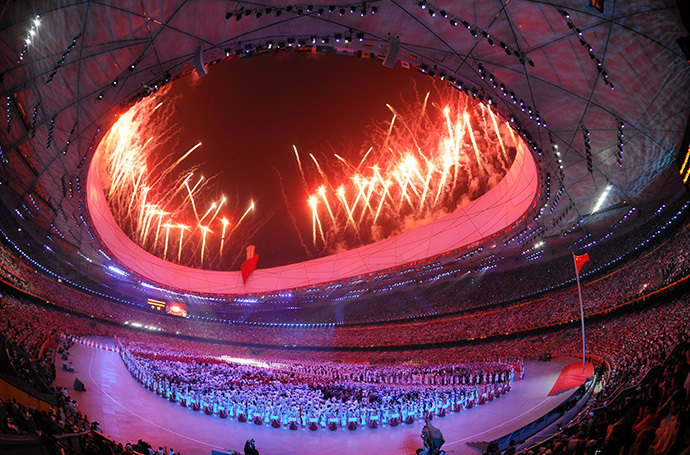 Delegations gather at the centre of the stadium as fireworks light up the sky during the opening ceremony of the 2008 Beijing Olympic Games in Beijing on August 8, 2008. (AFP Photo / Joe Klamar)