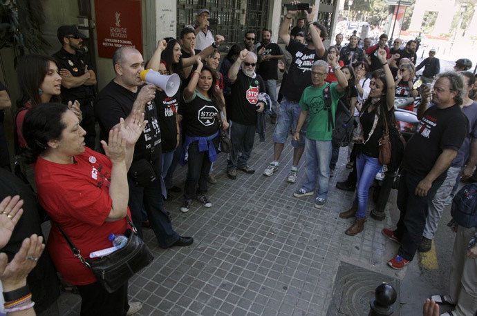 A protester delivers a speech through a megaphone during a demonstration outside the central employment office in Valencia, April 30, 2014. (Reuters/Heino Kali)