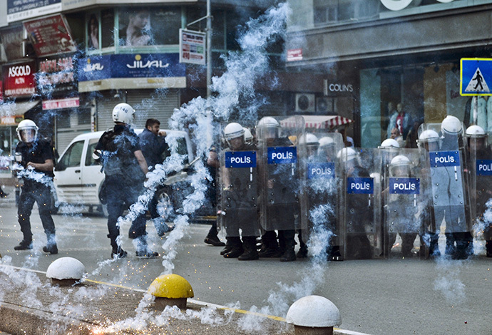 Turkish riot police take cover behing their shields as kurdish protestors use fireworks against them on June 1, 2014, during a demostration in the Gaziosmanpasa district of Istanbul on June 1, 2014. (AFP Photo / Ozan Kose)