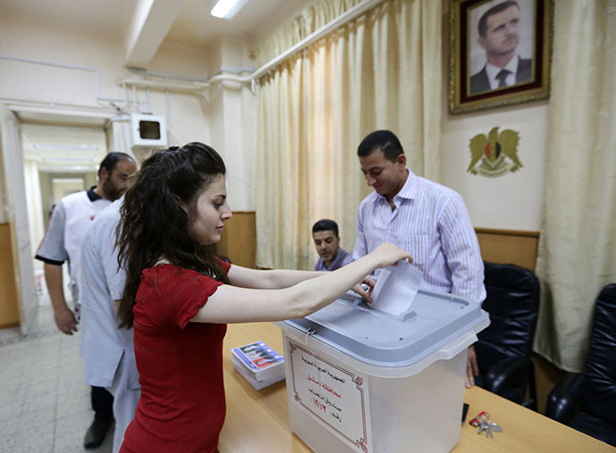 A Syrian woman casts her ballot as she votes in presidential election on June 3, 2014 at Bassel al-Assad school turned into a polling station in central Damascus (AFP Photo / Louai Beshara)