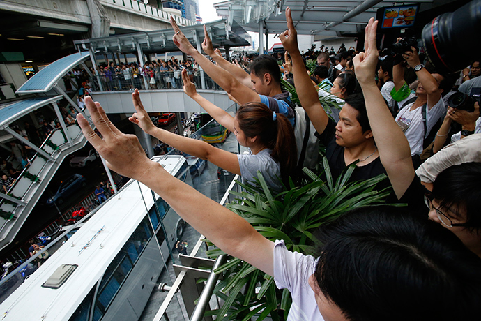 Protesters against military rule gesture by holding up their three middle fingers in the air, during a brief demonstration at a shopping mall in Bangkok June 1, 2014 (Reuters / Erik De Castro)