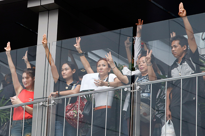 Protesters against military rule gesture by holding up their three middle fingers in the air, during a brief demonstration at a shopping mall in Bangkok June 1, 2014 (Reuters / Erik De Castro)
