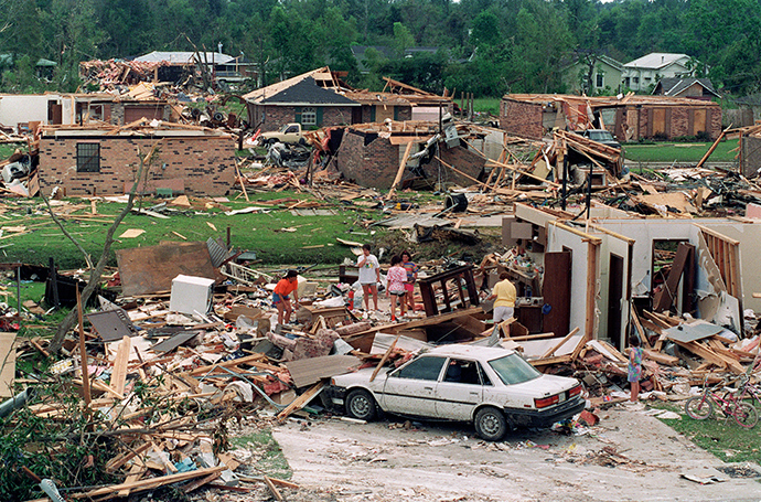 A group of people sift 28 August 1992 through the rubble of a house that was directly in the path of a 26 August tornado spawned by Hurricane Andrew (AFP Photo)