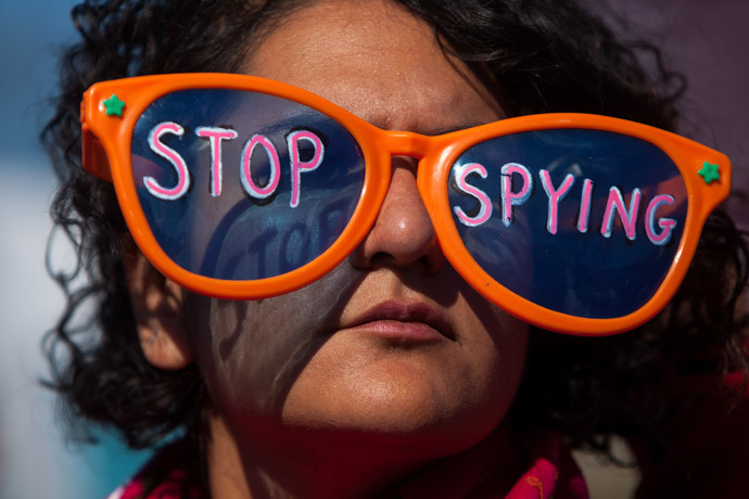 A woman wearing oversized sunglasses lettered with the words "stop spying" listens to speakers during the Stop Watching Us Rally protesting surveillance by the U.S. National Security Agency, on October 26, 2013, in front of the U.S. Capitol building in Washington, D.C.(AFP Photo / Allison Shelley)