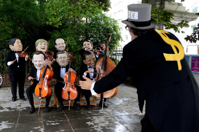  Oxfam charity activists wearing masks depicting G7 leaders protest on the sidelines of the G7 summit in front of European Council headquarters in Brussels, on June 4, 2014. (AFP Photo/Thierry Charlier)