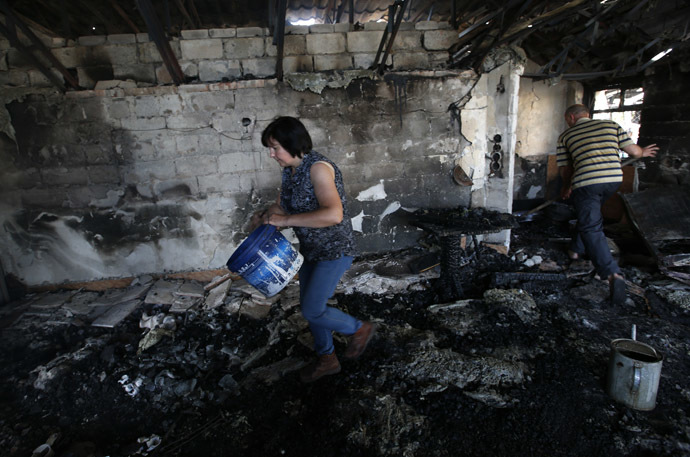 Local residents clean up debris from a destroyed building at a checkpoint in the eastern Ukrainian town of Slavyansk May 22, 2014. (Reuters/Maxim Zmeyev)