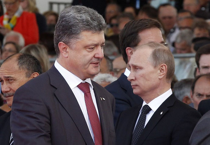 Ukraine's President-elect Petro Poroshenko (L) walks past Russian President Vladimir Putin during an international D-Day commemoration ceremony on the beach of Ouistreham, Normandy, on June 6, 2014, marking the 70th anniversary of the World War II Allied landings in Normandy. (AFP Photo / Christophe Ena)