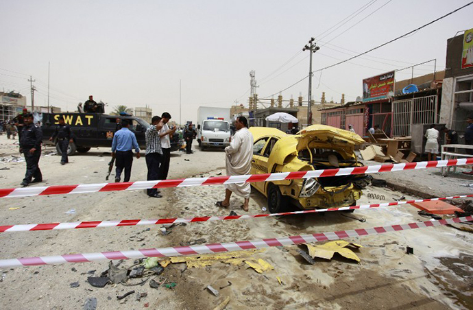 Iraqis inspect the site of a car bomb explosion that targeted a market in the central shrine city of Najaf on June 2, 2014, killing at least one person and wounding 20 others. (AFP Photo / Haidar Hamdani)