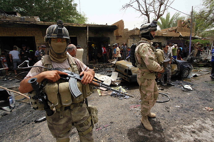 Iraqi security forces stand guard at the site of a car bomb attack at a market in the town of Iskandariya, June 2, 2014. (Reuters / Alaa Al-Marjani)