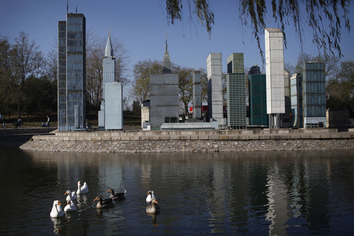 A flock of ducks swam pass the mini replica of Manhattan buildings in Beijing World Park, in the southwestern suburb of Beijing.(AFP Photo / China Out)