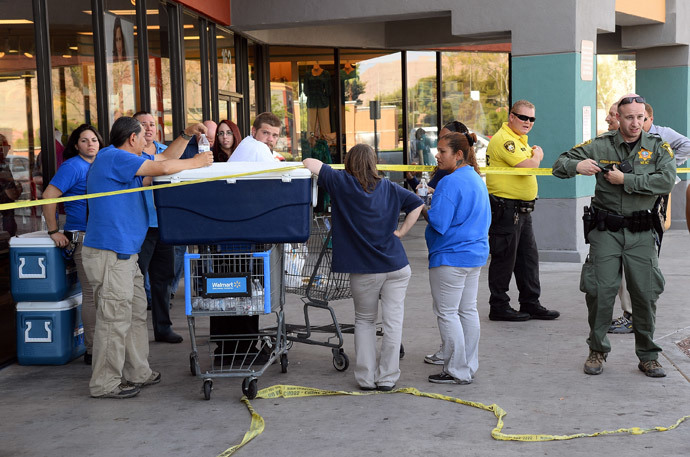Las Vegas Metropolitan Police Department officers stand near Wal-Mart employees near their store on June 8, 2014 in Las Vegas, Nevada.(AFP Photo / Ethan Miller)