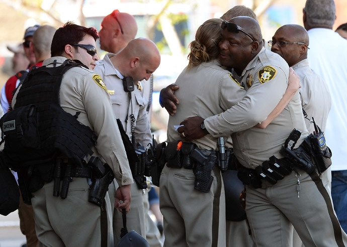 Las Vegas Metropolitan Police Department officers hug near a Wal-Mart on June 8, 2014 in Las Vegas, Nevada. (AFP Photo / Ethan Miller)