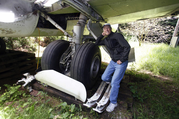 Bruce Campbell leans on a tyre of his Boeing 727 home in the woods outside the suburbs of Portland, Oregon May 21, 2014. (Reuters/Steve Dipaola)