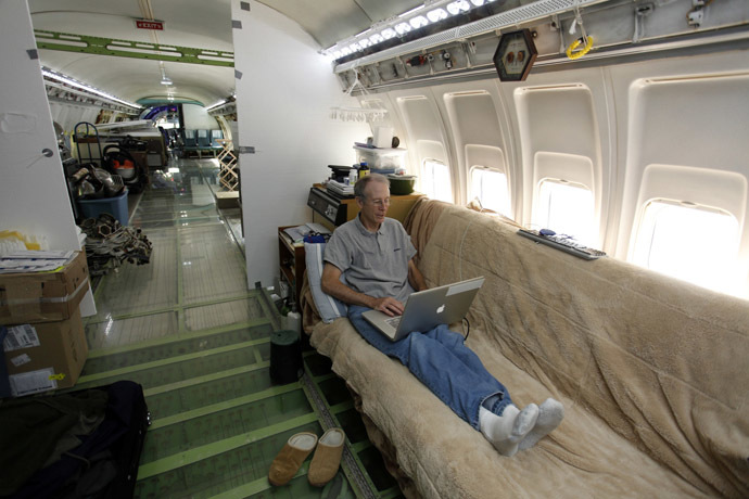 Bruce Campbell sits on his futon bed while using a laptop in his Boeing 727 home in the woods outside the suburbs of Portland, Oregon May 21, 2014. (Reuters/Steve Dipaola)