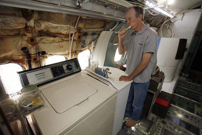 Bruce Campbell brushes his teeth at a sink in his Boeing 727 home in the woods outside the suburbs of Portland, Oregon May 21, 2014. (Reuters/Steve Dipaola)