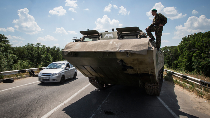 A self-defense fighter looks on from an amphibious vehicle near a road check point outside the eastern Ukrainian city of Lugansk June 8, 2014 (Reuters / Shamil Zhumatov)