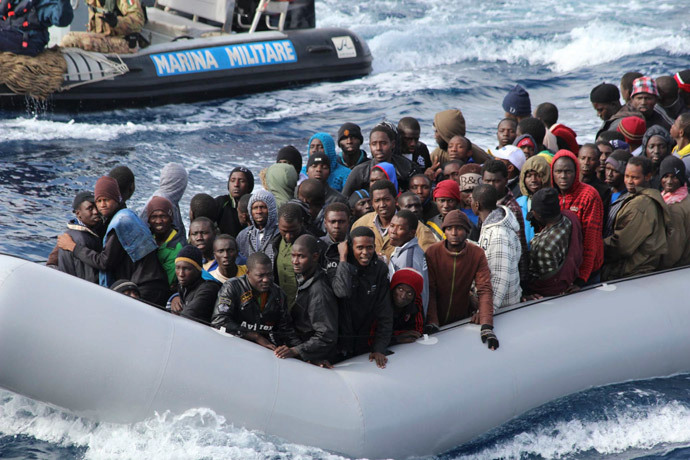 Migrants sit in a boat during a rescue operation by Italian navy off the coast of the south of the Italian island of Sicily.(Reuters / Marina Militare)