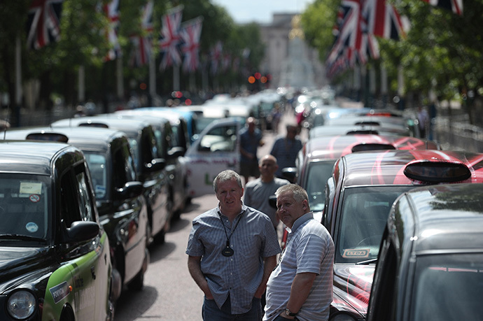  London black cab drivers take part in a protest against a new private taxi service 'Uber', a mobile phone app, on the Mall leading to Buckingham Palace in central London on June 11, 2014. (AFP Photo / Carl Court)