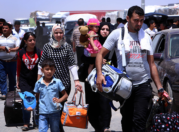 Iraqi families fleeing violence in the northern Nineveh province gather at a Kurdish checkpoint in Aski kalak, 40 kms West of Arbil, in the autonomous Kurdistan region (AFP Photo / Safin Hamed)