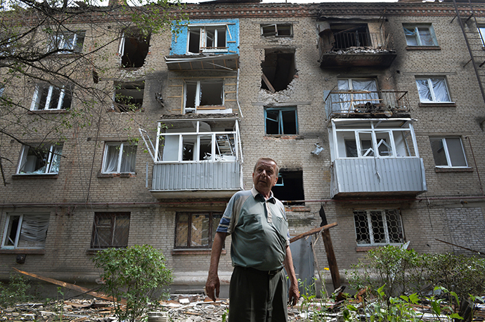 A local resident stands in front of the blown out windows and walls of a residential building after it was hit by mortar shells during clashes in the eastern Ukrainian city of Slavyansk, on June 11, 2014. (AFP Photo / Daniel Mihailescu)