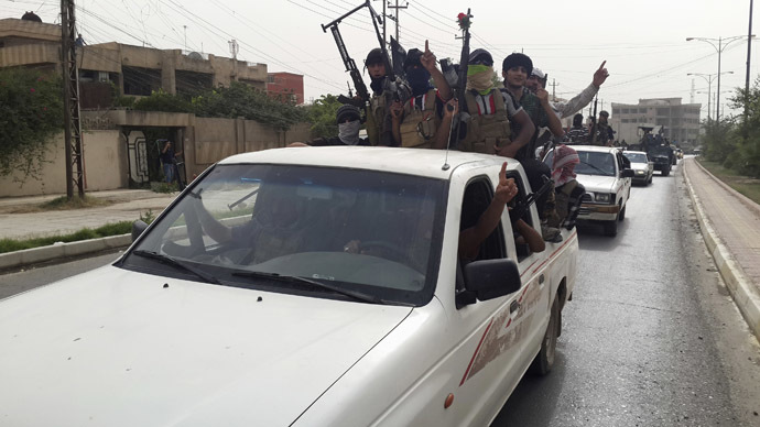 Fighters of the Islamic State of Iraq and the Levant (ISIL) celebrate on vehicles taken from Iraqi security forces, at a street in city of Mosul, June 12, 2014. (Reuters)