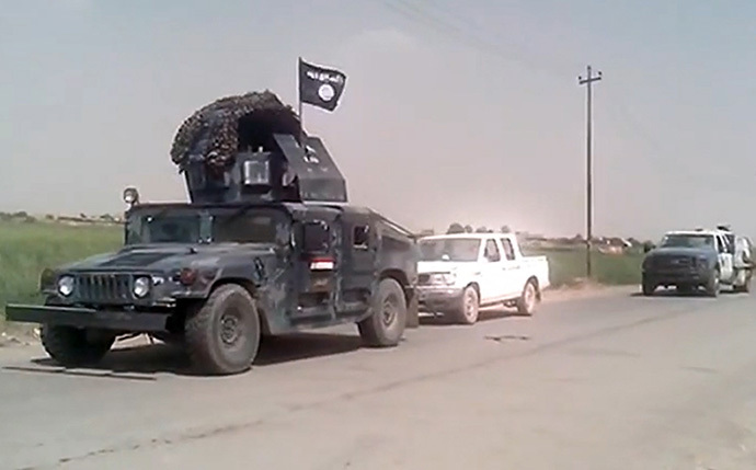 Captured Iraqi security forces vehicles mounted with the trademark Jihadists flag as they drive along a road in the northern city of Mosul on June 12, 2014.(AFP Photo / Youtube / Harith)